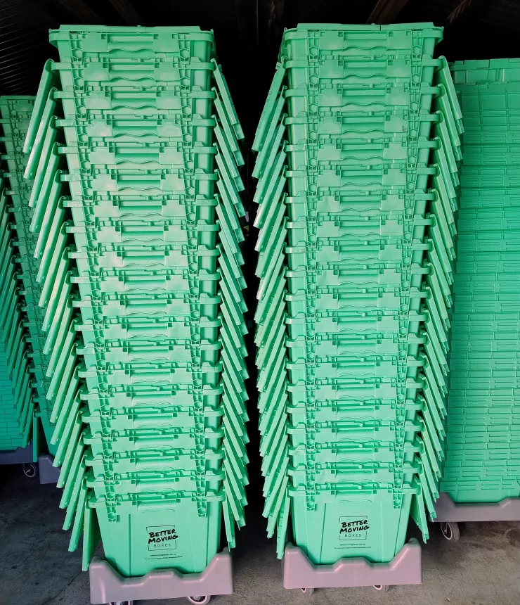 40 Strong plastic moving boxes stacked, on wheeled dollies